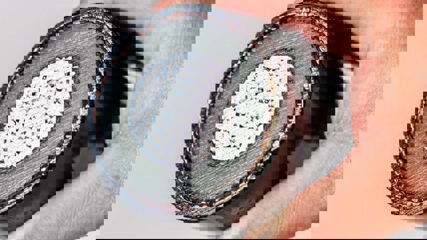 Mano che mostra la sezione di un cavo elettrico con conduttore, isolamento e guaina.