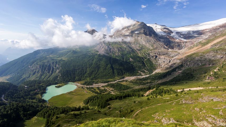 Aussicht auf das Tal mit dem türkisfarbenen See Palü, umgeben von Wäldern und Bergen mit Gletscher.
