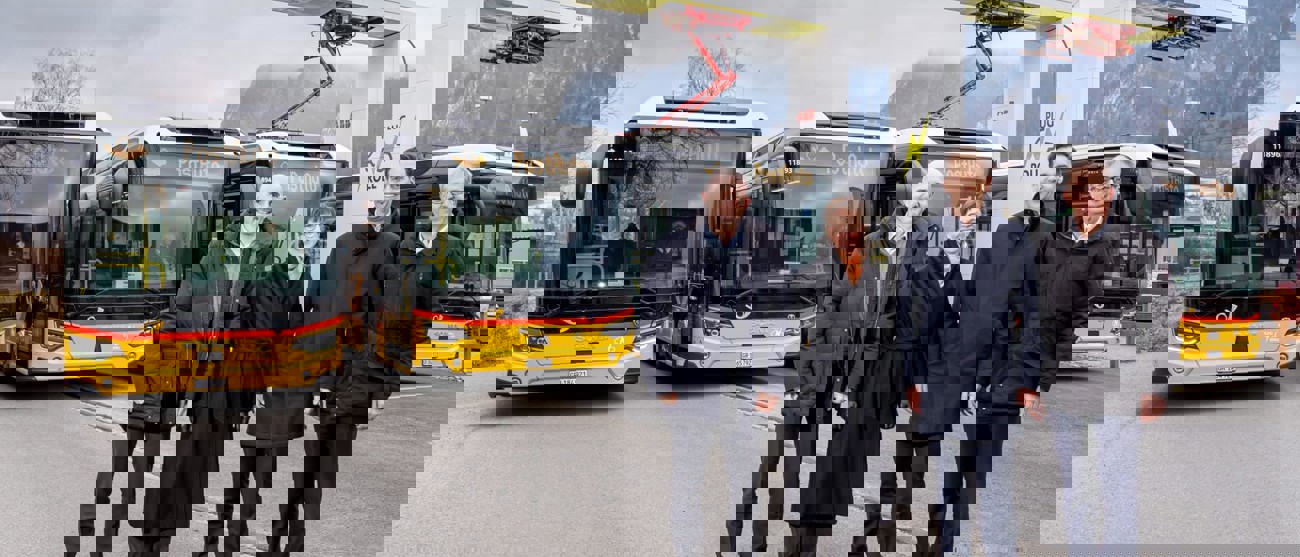 Plug’n Roll-Ladestation mit den ersten Elektropostautos für Graubünden und Vertreter:innen vor Ort.