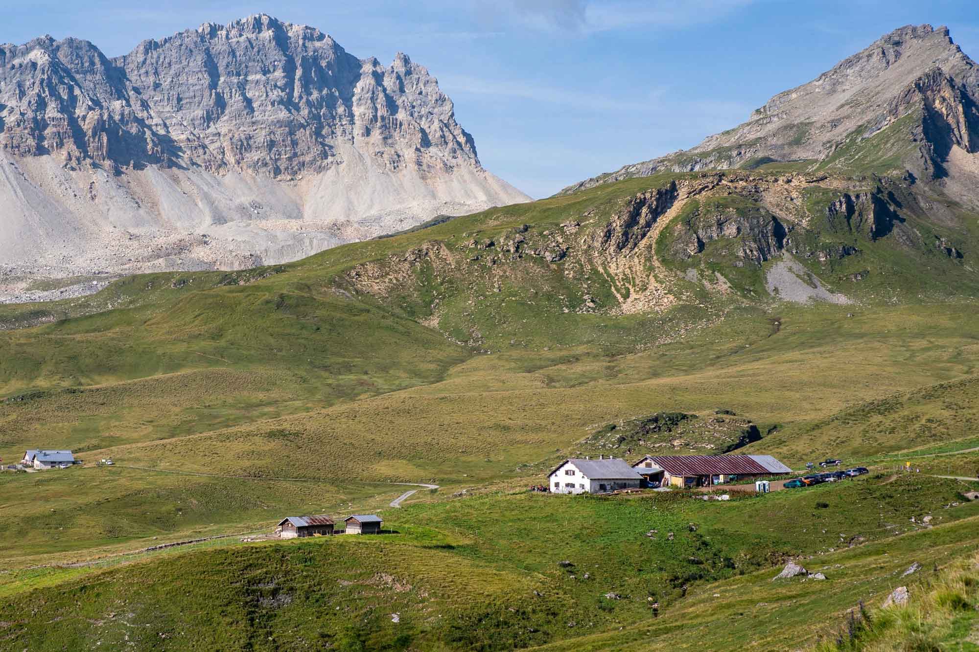 L'alp Curtginatsch con i suoi edifici e il panorama montano in estate