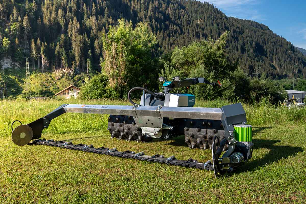 Trattore elettrico a un asse “Monotrac” con barra falciante in un prato di montagna nei Grigioni