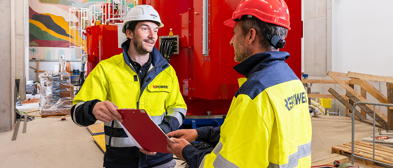 Due collaboratori Repower con casco e giacca in centrale – risultato annuo straordinario grazie al trading.