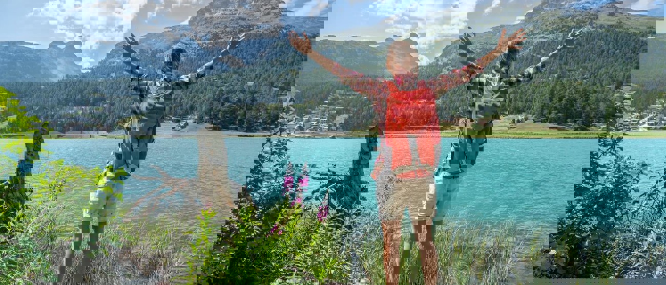 Wanderin am See in den Bündner Bergen – Symbolbild für ein solides Halbjahresergebnis von Repower.