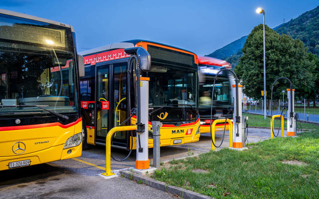 DC-Ladeinfrastruktur im PostAuto Depot Bellinzona mit drei Kempower Satelliten und Postautos, die ihre Batterien aufladen.